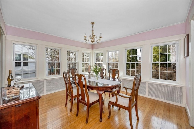 dining room with baseboards, wallpapered walls, ornamental molding, light wood-style floors, and a notable chandelier