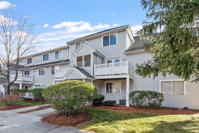 multi unit property with a front yard, cooling unit, and a balcony