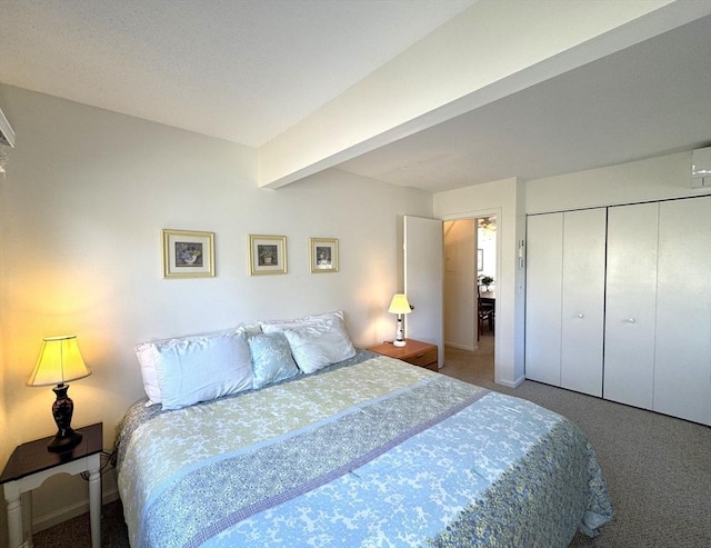 carpeted bedroom with beam ceiling, baseboards, and a closet