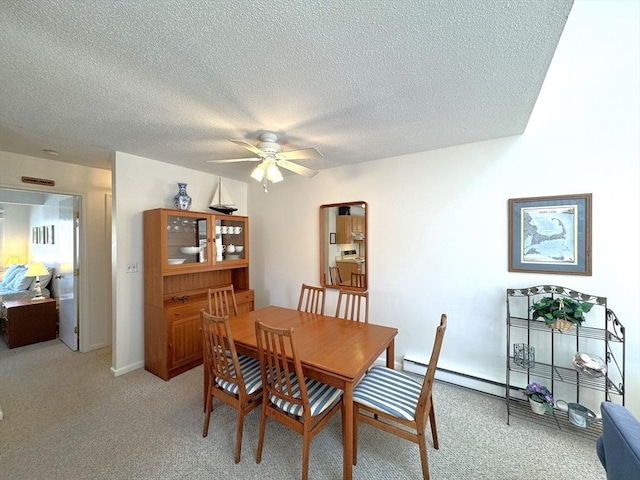 dining area with light colored carpet, a ceiling fan, and a textured ceiling