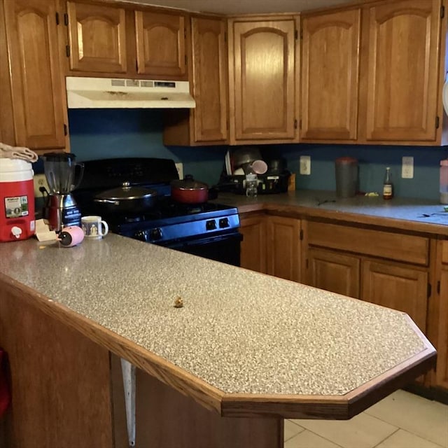 kitchen featuring black electric range oven, kitchen peninsula, and light tile patterned floors