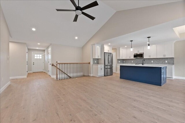 unfurnished living room featuring high vaulted ceiling, sink, ceiling fan, and light hardwood / wood-style flooring