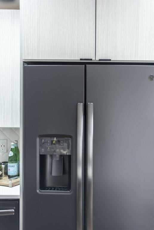 interior details with light countertops and stainless steel fridge with ice dispenser