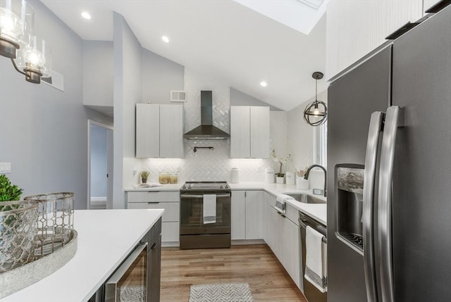 kitchen featuring beverage cooler, range with electric cooktop, a sink, stainless steel fridge with ice dispenser, and wall chimney exhaust hood