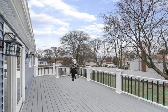 wooden terrace with a residential view, fence, and a lawn