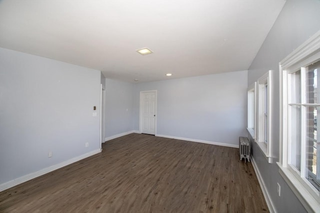 unfurnished room with dark wood finished floors, radiator heating unit, and baseboards