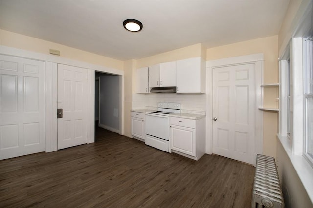 kitchen featuring under cabinet range hood, radiator heating unit, light countertops, electric stove, and white cabinets