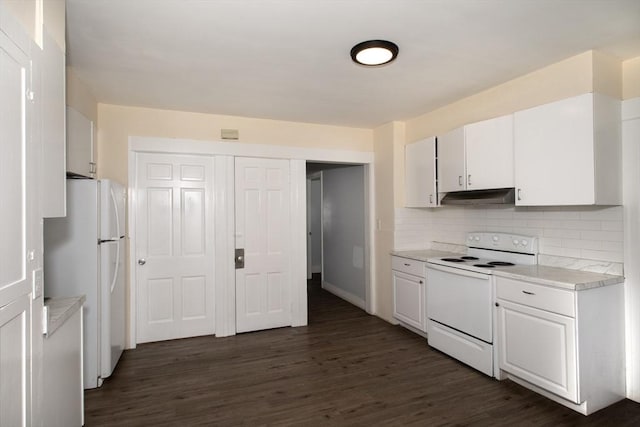 kitchen with dark wood-type flooring, under cabinet range hood, tasteful backsplash, white appliances, and light countertops