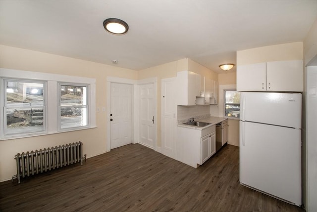 kitchen featuring radiator, dishwasher, freestanding refrigerator, white cabinets, and a sink