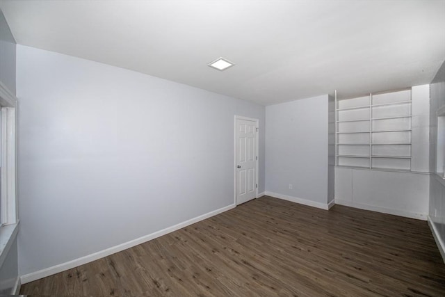 empty room with baseboards and wood finished floors