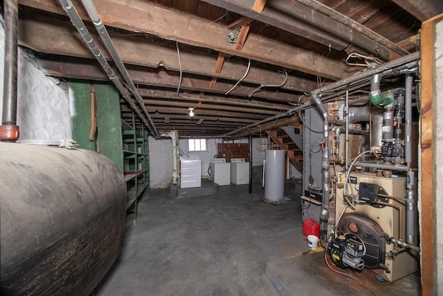 basement with washing machine and dryer, gas water heater, and heating fuel