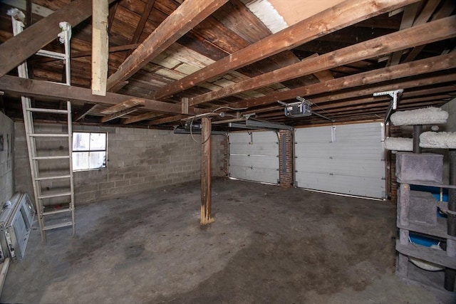 garage featuring concrete block wall and a garage door opener