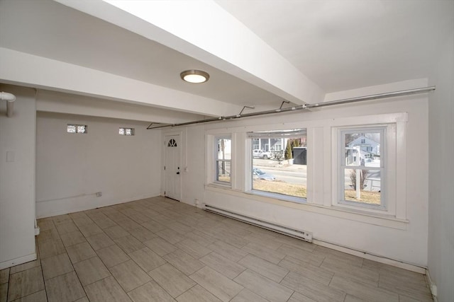 spare room featuring beamed ceiling, a wealth of natural light, and a baseboard radiator