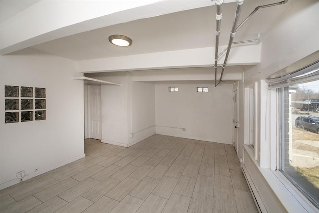 basement featuring wood finish floors and baseboards