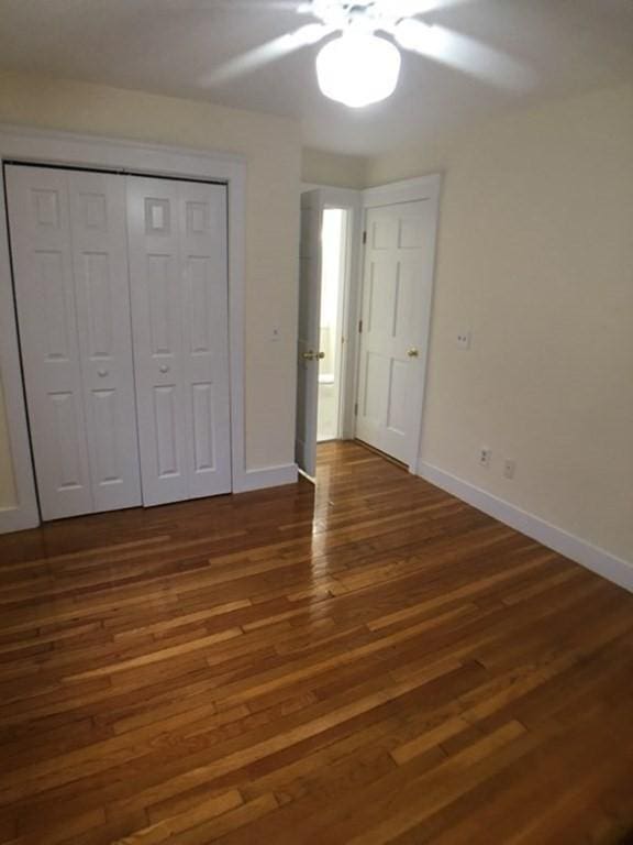 589-591 Washington St, Brookline, MA 02446 - unfurnished bedroom with wood finished floors, baseboards, a ceiling fan, and a closet