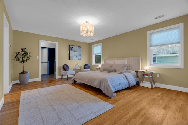 bedroom featuring light hardwood / wood-style flooring and a chandelier