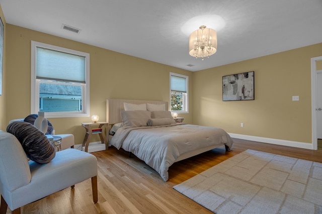 bedroom featuring light hardwood / wood-style floors and a chandelier