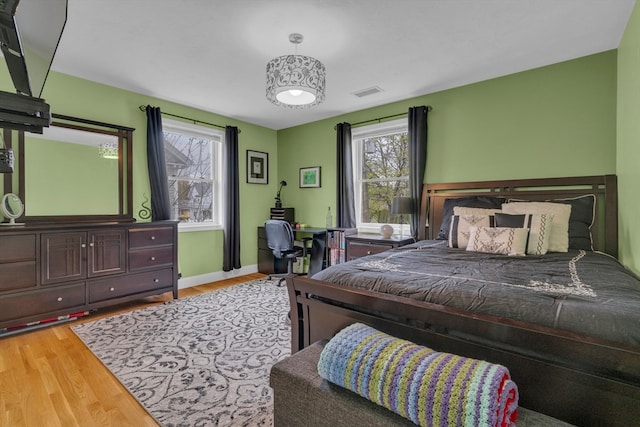 bedroom with hardwood / wood-style flooring and multiple windows