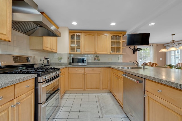 kitchen with light brown cabinets, sink, wall chimney range hood, and appliances with stainless steel finishes