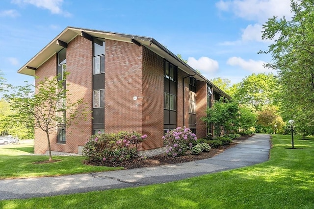 7 Longwood Dr Unit 212, Andover, MA 01810 - view of home's exterior featuring a yard and brick siding