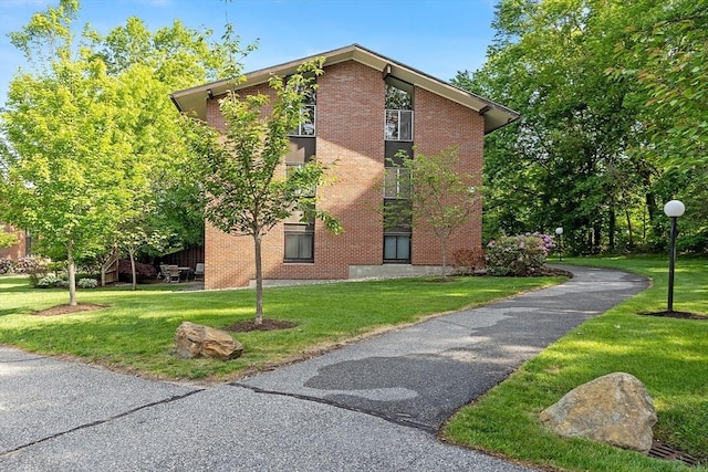 7 Longwood Dr Unit 212, Andover, MA 01810 - view of home's exterior with brick siding and a lawn