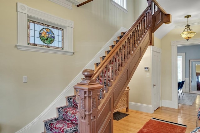 stairway with a wealth of natural light and hardwood / wood-style floors