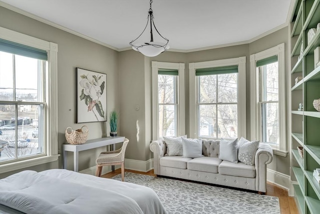 bedroom with multiple windows, wood-type flooring, and ornamental molding