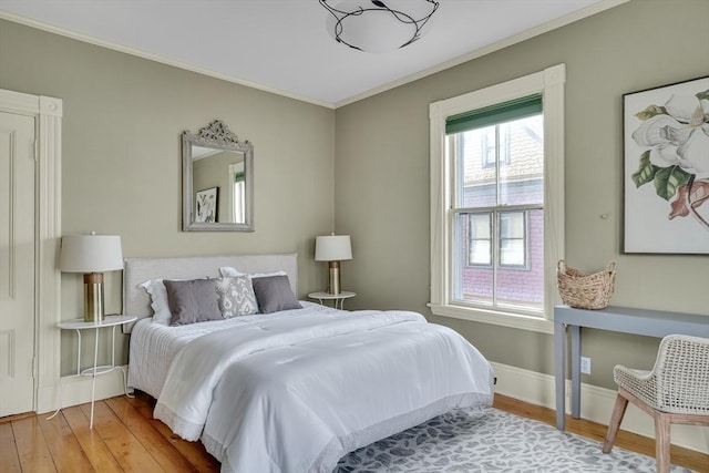 bedroom with hardwood / wood-style flooring and crown molding