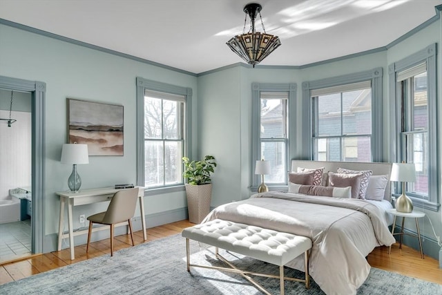 bedroom featuring an inviting chandelier, ornamental molding, hardwood / wood-style flooring, and multiple windows