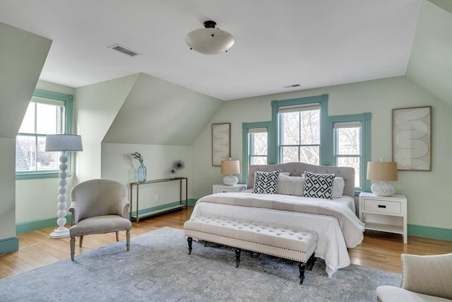 bedroom featuring light hardwood / wood-style floors and lofted ceiling