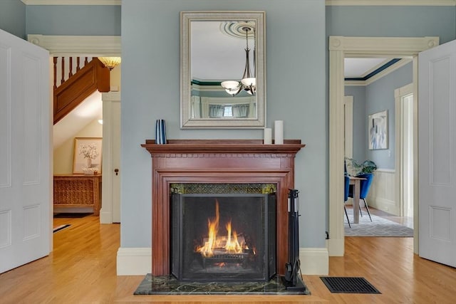 room details with a notable chandelier, ornamental molding, and hardwood / wood-style flooring