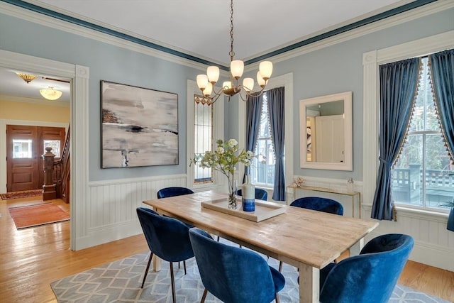 dining space featuring ornamental molding, light hardwood / wood-style floors, and a chandelier