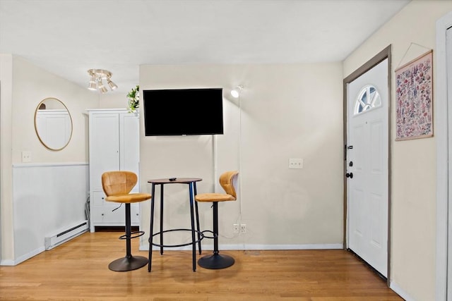 foyer featuring baseboard heating and light hardwood / wood-style flooring