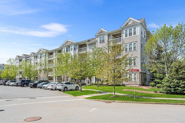 view of apartment building / complex featuring uncovered parking