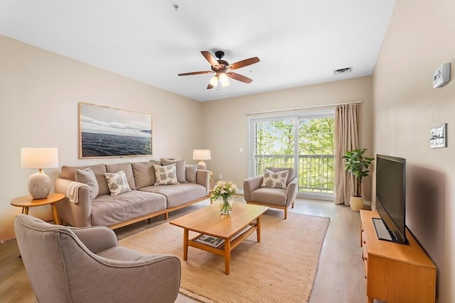 living room with light wood-type flooring and a ceiling fan