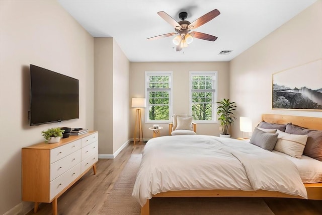 bedroom featuring light wood finished floors, baseboards, and a ceiling fan