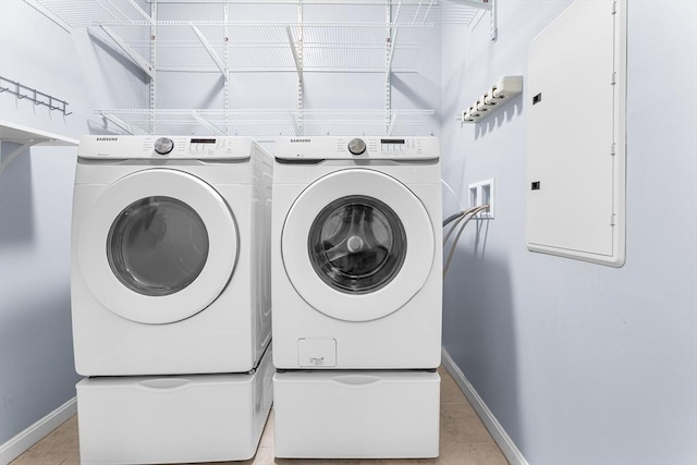 laundry room with washer and dryer, baseboards, and light tile patterned floors