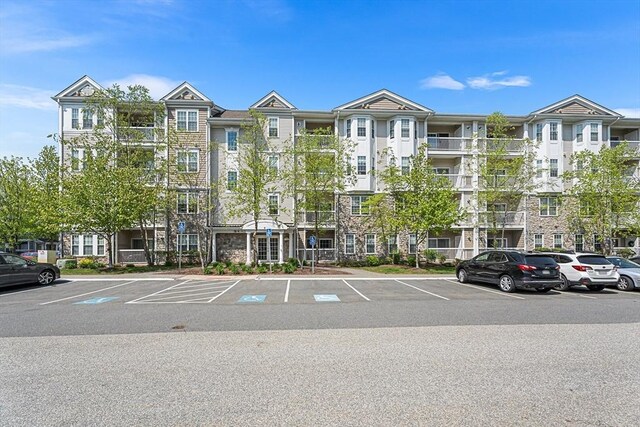 view of apartment building / complex featuring uncovered parking