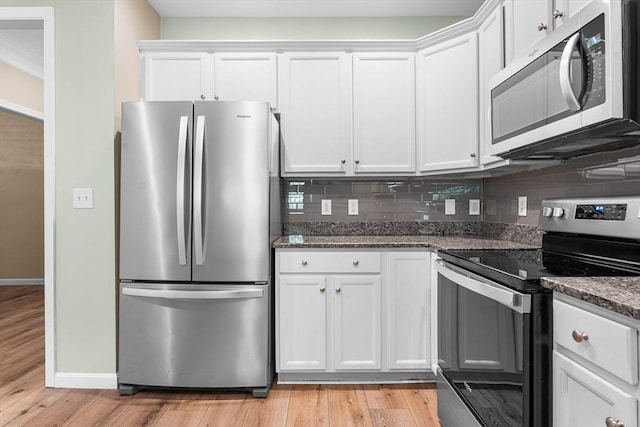 kitchen featuring appliances with stainless steel finishes, white cabinets, tasteful backsplash, and dark stone counters