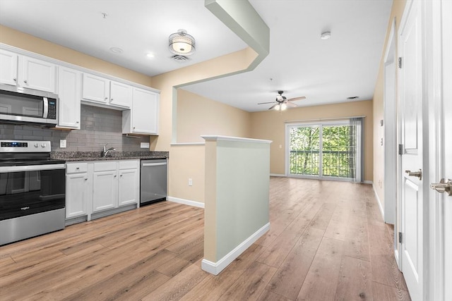 kitchen with appliances with stainless steel finishes, baseboards, light wood-type flooring, a ceiling fan, and white cabinets