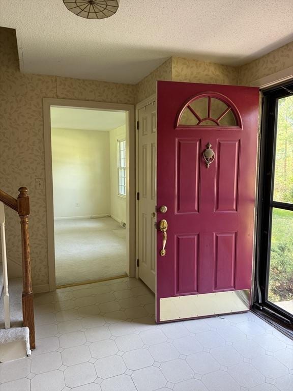 6 J William Hts, Millis, MA 02054 - foyer featuring light flooring, wallpapered walls, a textured ceiling, and stairs