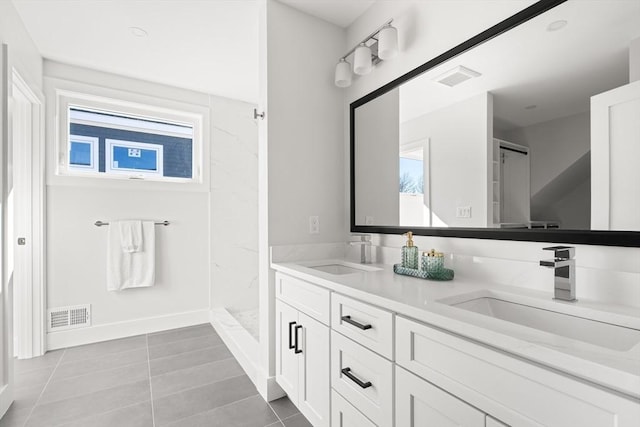 bathroom featuring tile patterned floors, walk in shower, double vanity, and baseboards