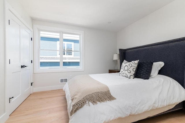 bedroom with light wood finished floors and baseboards