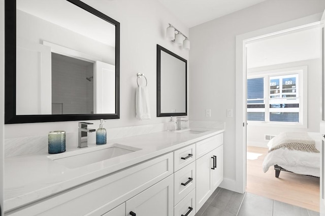 full bath with double vanity, tile patterned floors, and baseboards
