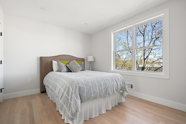 bedroom with baseboards and wood finished floors
