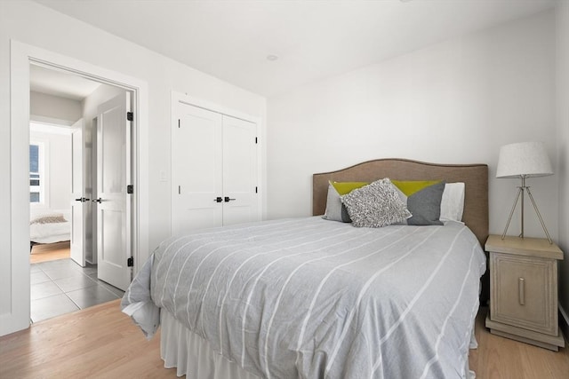 bedroom with wood finished floors and a closet