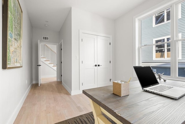 office space featuring light wood-type flooring and baseboards