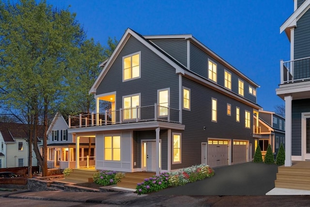 view of front of house featuring a balcony, a garage, and driveway