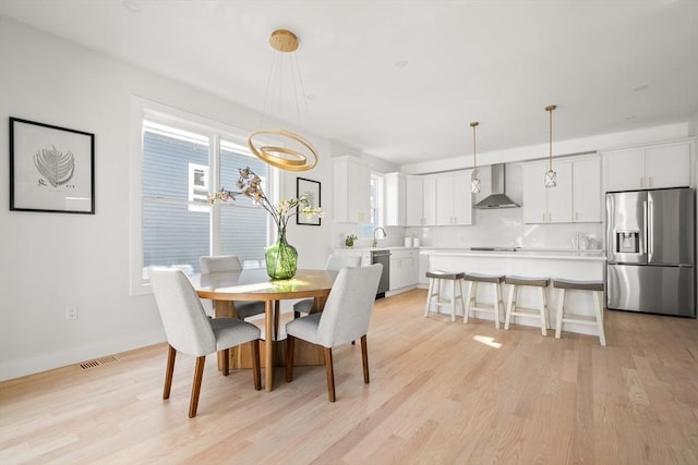 dining room with light wood-style flooring and baseboards