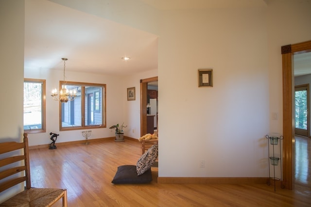 interior space with an inviting chandelier, light hardwood / wood-style flooring, and a healthy amount of sunlight